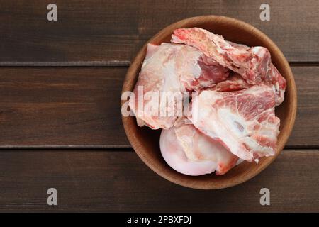 Bol en os de viande hachés crus sur une table en bois, vue de dessus. Espace pour le texte Banque D'Images