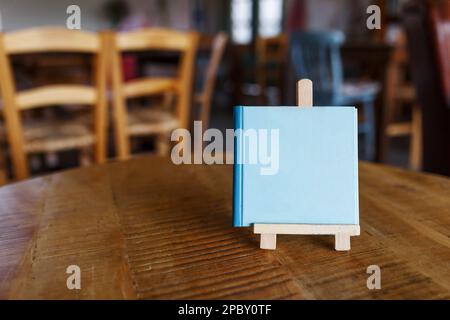 Maquette menu objet dans le café et le restaurant, écran vierge pour livret avec feuilles blanches de papier sur table en bois sur la cafétéria, promotion et information Banque D'Images