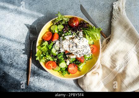 Concept de saine alimentation avec salade de légumes crus goûtés de graines de sésame dans le bol Banque D'Images
