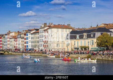 Les gens qui profitent du soleil tout en regardant la course en bateau à Bayonne, France Banque D'Images