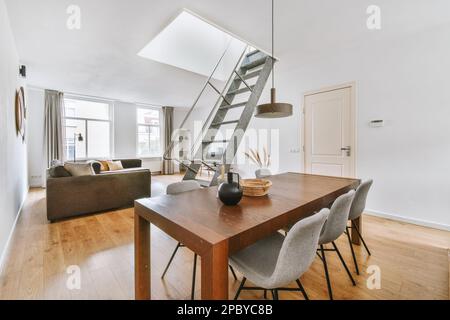 Décoration intérieure de la salle à manger avec table et chaises en bois avec échelle de grenier pliante dans l'appartement moderne Banque D'Images