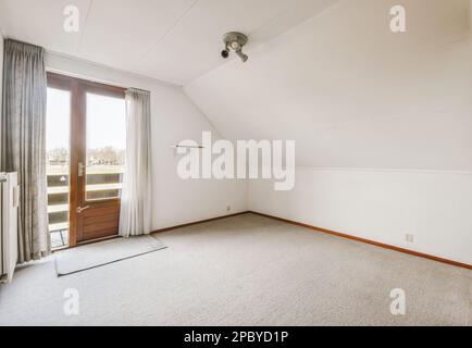 Décoration intérieure de chambre lumineuse avec fenêtre en bois et porte de balcon avec rideaux gris près du radiateur avec moquette Banque D'Images