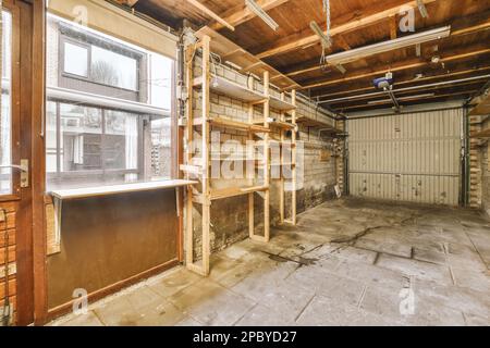 Intérieur d'un vieux garage miteux avec des murs en briques et des étagères près des placards éclairés par des lampes Banque D'Images