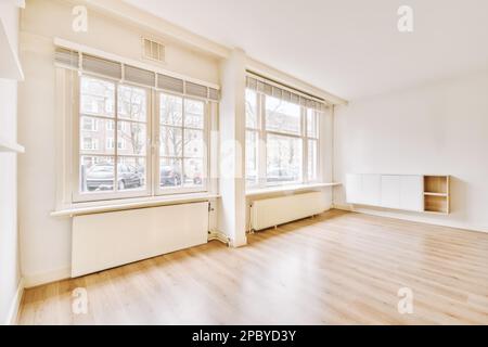 Décoration intérieure de la maison de style contemporain avec portes arrière coulissantes en verre près du radiateur avec cheminée vide et étagère sur le mur avec murs blancs et Banque D'Images