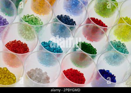 plusieurs granulés de résine de plastique coloré transparent sont en laboratoire dans des verres d'essai. Masse pour le processus de moulage par injection et d'extrusion Banque D'Images