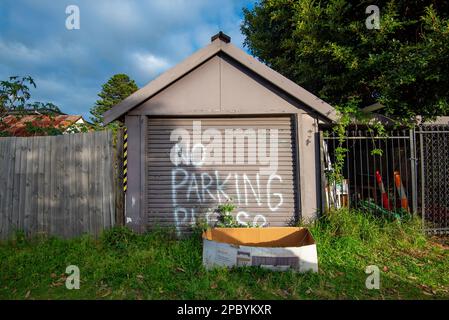 Pas de parking, veuillez faire une affiche peinte à la main sur un garage à roulettes à Ettalong, Nouvelle-Galles du Sud, Australie Banque D'Images