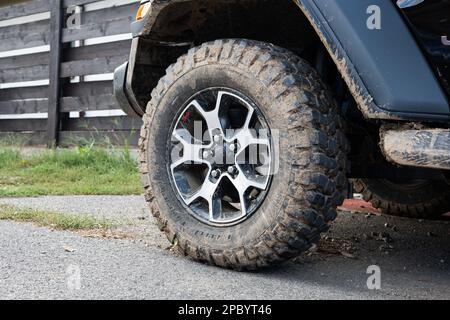 Boue séchée sur les pneus de boue tout-terrain du SUV. Gros plan, vue en angle bas, pas de personne. Banque D'Images