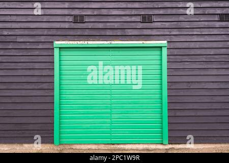 Porte verte en bois sur une grange noire. Banque D'Images