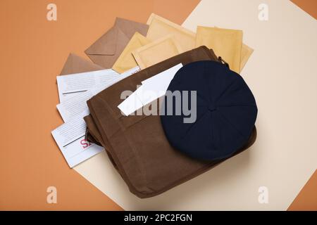 Sac de postman, journaux, mails et chapeau sur fond de couleur, plat Banque D'Images