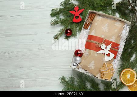 Emballage de Noël Stollen dans une boîte et décoration sur une table en bois blanc, plat. Espace pour le texte Banque D'Images