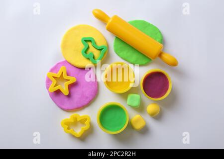 Ensemble d'outils et pâte de jeu de couleur sur fond blanc, vue de dessus Banque D'Images