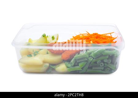 Pommes de terre savoureuses avec des côtelettes et des légumes dans un récipient en plastique isolé sur blanc Banque D'Images