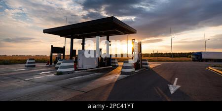 Station-service moderne en libre-service sur fond de ciel spectaculaire au coucher du soleil Banque D'Images