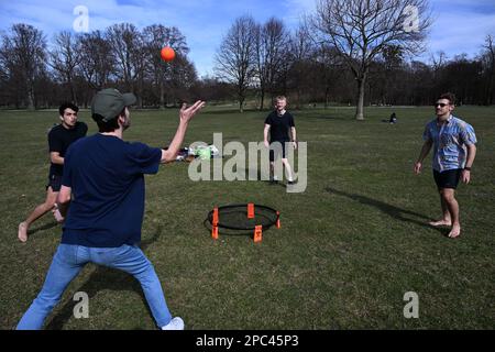 Munich, Allemagne. 13th mars 2023. Leon, Rolf, Jonas et Laurenz jouent du spikeball dans les températures printanières du jardin anglais. Le soleil attire les gens dans la capitale de l'État en plein air. Credit: Felix Hörhager/dpa/Alay Live News Banque D'Images