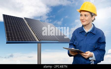 Femme ingénieur avec un ordinateur de tablette sur un fond d'éoliennes et de panneaux solaires Banque D'Images