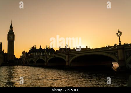 Les touristes anonymes traversent le pont de Westminster en direction du Parlement et de Big Ben au coucher du soleil à Londres, en Angleterre Banque D'Images