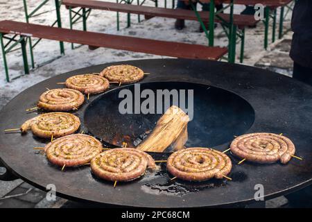 Saucisses en spirale préparées avec de la viande hachée grillée ou rôtie au barbecue sur le feu de cheminée Banque D'Images