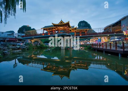 Un pont orné dans une ville orientale se reflète sur la surface de l'eau. Banque D'Images