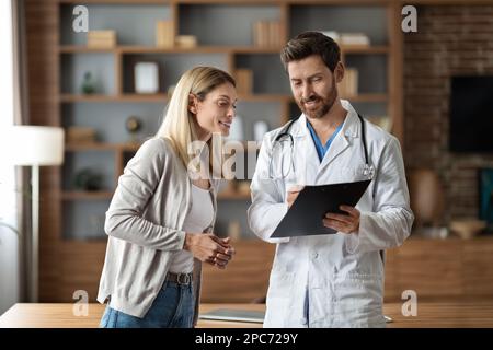 Médecin de sexe masculin discutant du traitement médical à un patient de sexe féminin pendant une réunion en clinique Banque D'Images