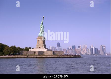 Vue sur la Statue de la liberté, avec les gratte-ciel de Manhattan Island à distance, Liberty Island, New York Harbour, New York City, New York State (U.) S. A. Banque D'Images