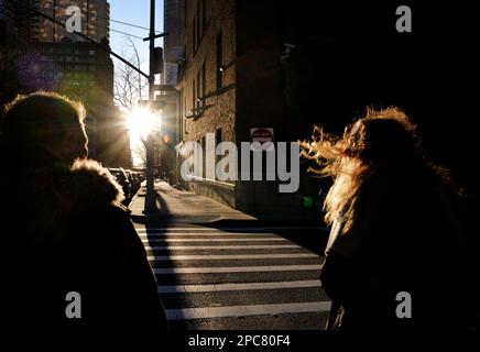 Les gens qui marchent dans une rue de New York City sous le soleil du matin Banque D'Images