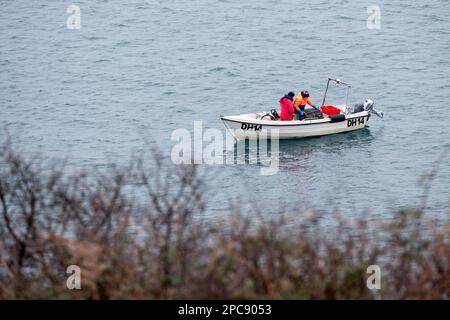 Deux pêcheurs dans un petit bateau transportent à bord d'un pot de homard ou d'un piège à homard de la mer après qu'il ait été laissé à l'endroit plus tôt dans la journée Banque D'Images