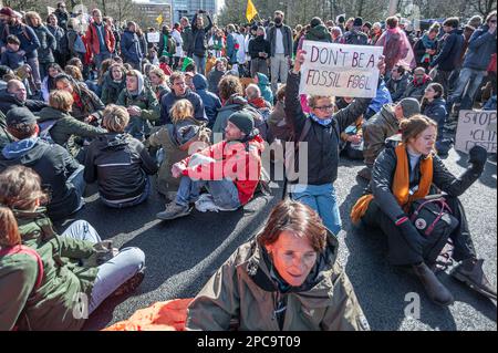 Un activiste tient un écriteau qui se lit «ne PAS ÊTRE Un IMBÉCILE FOSSILE» pendant la démonstration. Extinction la rébellion a organisé cet après-midi un blocus sur l'autoroute A12 à la Haye, malgré l'interdiction de la municipalité. La police est intervenue après la date limite de 5 heures. Vers 5:10, la police a commencé à briser la manifestation. Le fameux « jet de grenouille » du canon à eau allemand a été utilisé pour disperser les manifestants lors de leur sit-down, ce qui a eu très peu d'effet car la plupart d'entre eux étaient préparés à un tel événement. Selon la rébellion de l'extinction, plus de 3 000 000 manifestants ont été impliqués Banque D'Images