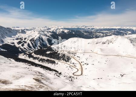 Vue aérienne de l'US Highway 6 qui se courbe vers Loeland Pass, Colorado Summit, un après-midi d'hiver ensoleillé. Banque D'Images