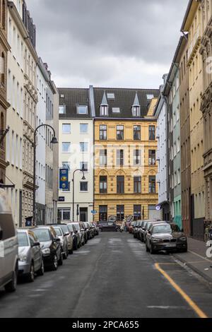 Voitures garées dans une rue étroite de Cologne par une journée d'hiver Banque D'Images