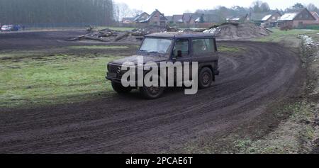 Itterbeck, Allemagne 12 mars 2023 Une jeep Mercedes totalement sale conduite sur une piste hors route à travers la boue. C'est une Mercedes-Benz classe G W460 Banque D'Images