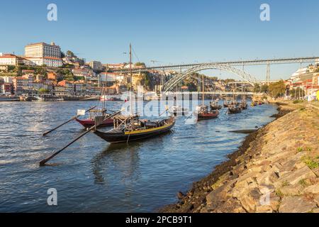 Des bateaux Rabelo amarrés sur le fleuve Douro, avec la ville de Porto et le pont D. Luís en arrière-plan, un après-midi d'été. Banque D'Images