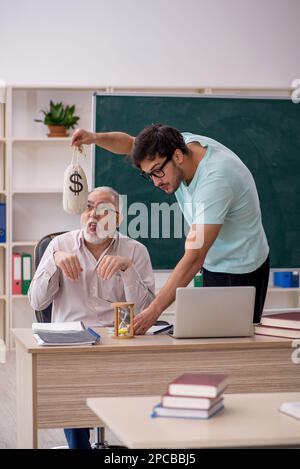 Vieux professeur et jeune étudiant dans le concept de rémunération Banque D'Images