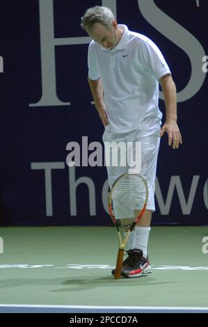 American tennis legend John McEnroe, flips the racket with his leg, while playing against, Sweden's legend Bjorn Borg, during the Legends exhibition match at the Madinat Jumeira indoor tennis court, in Dubai, United Arab Emirates, Thursday Nov. 2, 2006. (AP Photo/Aziz Shah)