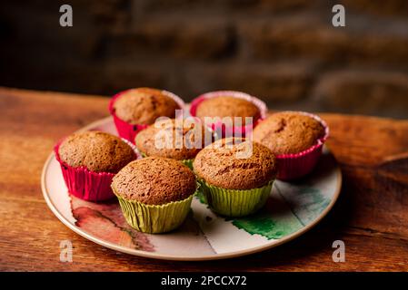 Petits gâteaux faits maison sous forme de papier sur table en bois sur fond sombre. Banque D'Images