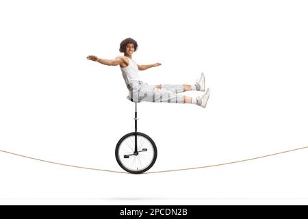 L'américain africain acrobat mâle assis sur un monocycle au-dessus d'une corde isolée sur fond blanc Banque D'Images