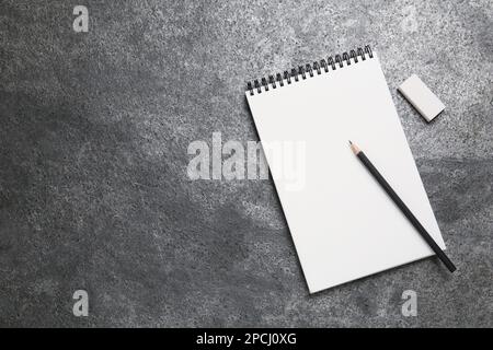 Carnet d'esquisses, crayon et gomme sur table en pierre grise. Espace pour le texte Banque D'Images