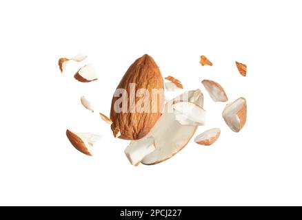 Morceaux d'amandes savoureuses tombant sur fond blanc Banque D'Images