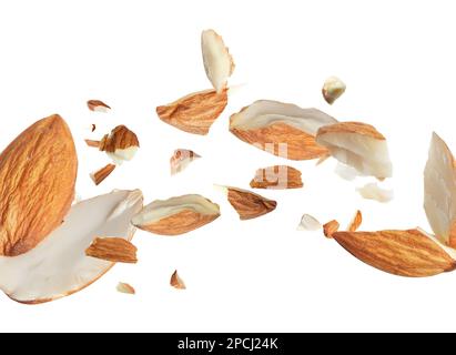 Morceaux d'amandes savoureuses tombant sur fond blanc Banque D'Images