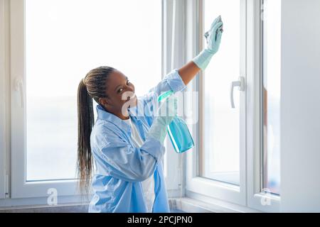 Femme de ménage ou femme de ménage bonne femme de ménage nettoyer les fenêtres Banque D'Images