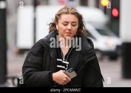 Londres, Royaume-Uni. 13th mars 2023. Une femme tient son téléphone portable tout en marchant dans la rue à Londres. Crédit : SOPA Images Limited/Alamy Live News Banque D'Images