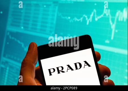 Chine. 15th févr. 2023. Dans cette illustration, le logo de la société italienne de mode de luxe Prada est affiché sur un smartphone avec un graphique d'indice boursier économique en arrière-plan. Crédit : SOPA Images Limited/Alamy Live News Banque D'Images