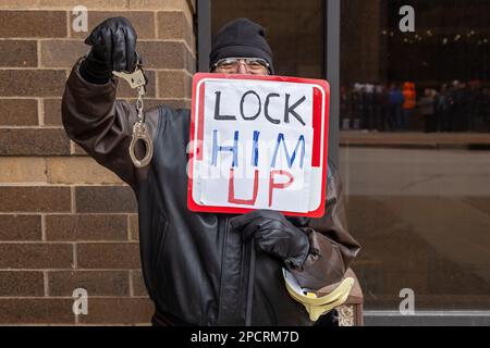 Davenport, Iowa, États-Unis. 13th mars 2023. Les manifestants anti-Trump ont organisé un piquet de grève en face du rassemblement de campagne de l'ancien président Donald Trump au Adler Theatre de Davenport, Iowa, États-Unis, le 13th mars 2023. Un manifestant tenait un panneau de verrouillage et un ensemble de menottes. Trump en est à sa troisième campagne primaire pour la présidence des États-Unis en 2024. Crédit : Keith Turrill/Alamy Live News Banque D'Images