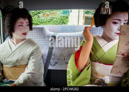 Fukuyu,geisha et Fukukimi,'maiko' (apprenti geisha) en taxi allant au travail.Geisha distrait de Miyagawacho.Kyoto. Kansai, Japon. Banque D'Images