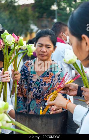 Phnom Penh, Cambodge-23 décembre 2023: Le long de la promenade du bord de rivière, les hommes, les femmes et les familles Khmers se rassemblent dans les relativement cool, tard après-midi Banque D'Images