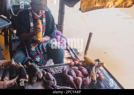 Marché flottant de Pattaya, le bateau stalles au marché flottant, un vendeur mâle vendant du maïs, concentration sélective Banque D'Images