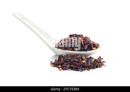 Flocons de piment sec fumé. Poivrons rouges écrasés isolés sur fond blanc. Banque D'Images