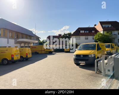 Allemagne - 28 mai 2022: Fourgonnette de livraison de poste jaune multiple VW Deutsche Post dans le parking d'une gare postale Banque D'Images