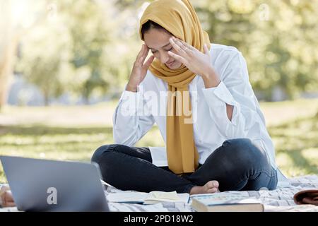 Stress, islamique et femme étudiant avec un mal de tête tout en étudiant dans un parc sentiment frustré et triste à l'extérieur. Portable, malade et musulmane femme avec un Banque D'Images