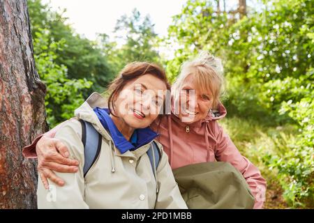 Portrait d'une femme âgée heureuse assise avec une amie en forêt pendant les vacances Banque D'Images