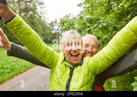 Portrait d'un couple de personnes âgées gaies portant une veste de randonnée dans la forêt pendant les vacances Banque D'Images
